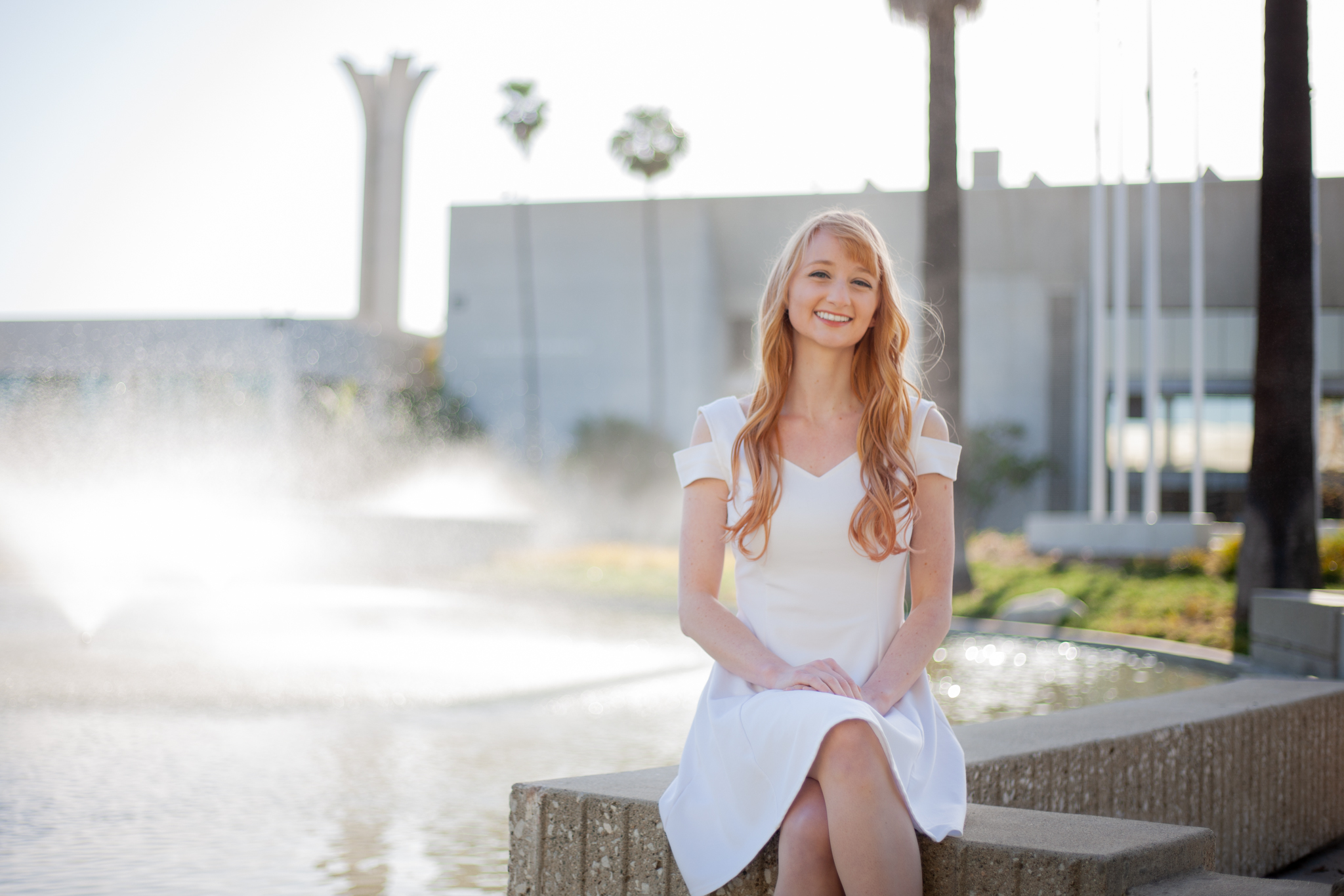 Student Lia Thompson sits in front of pond and fountain on Cypress College campus.