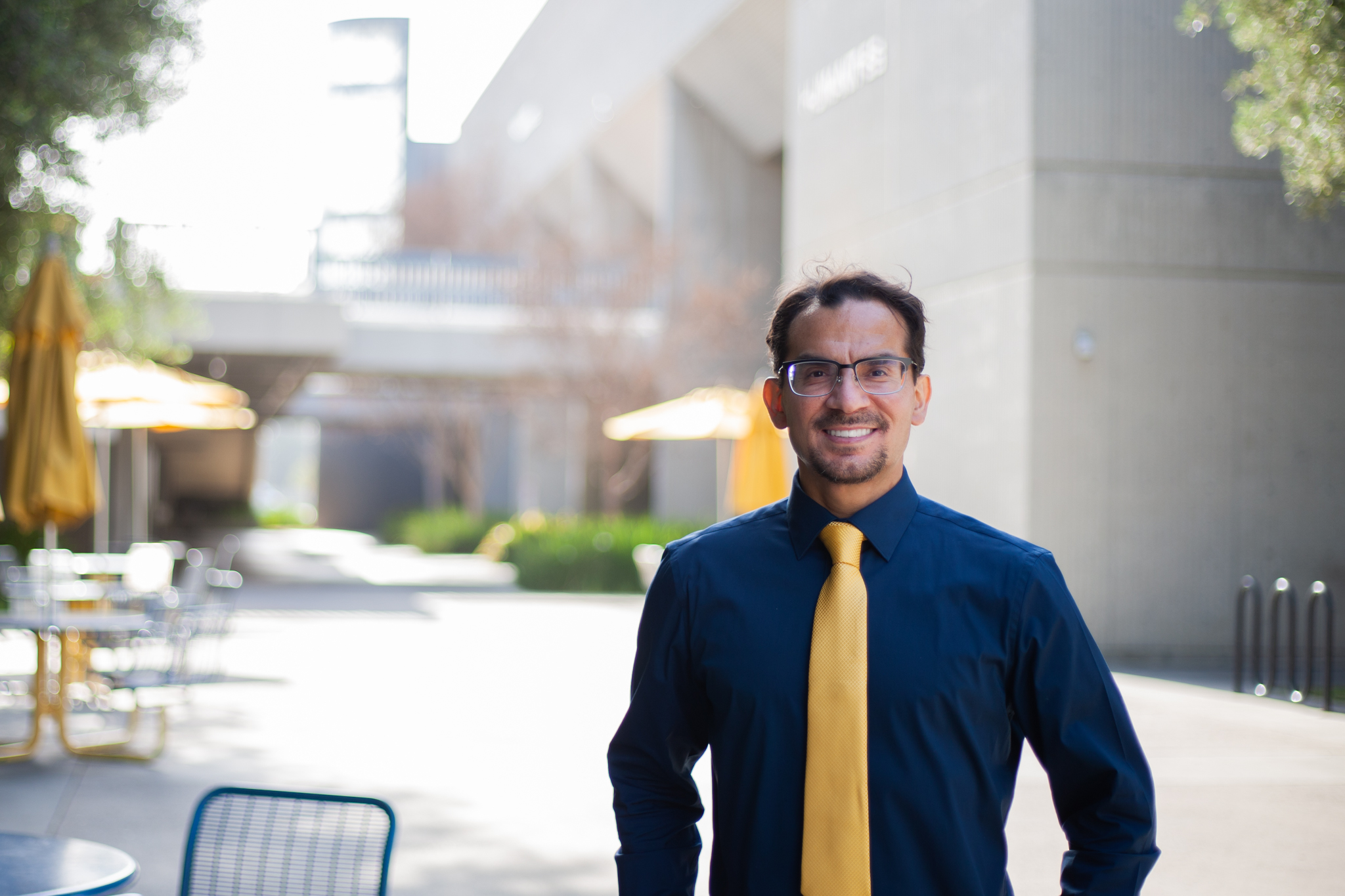 Wilfredo Carrasco poses on Cypress College campus wearing blue and gold. 