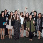 Group of Scholarship Award Ceremony attendees smiling and holding ribbon tied scrolls.