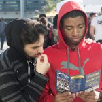 Two young men looking at a Cypress Athletics brochure