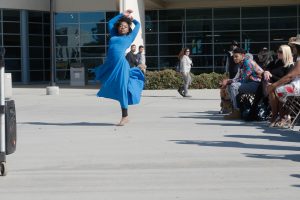 Girl in a blue dress dancing.