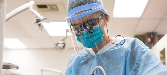 Student wearing personal protective equipment while working on teeth