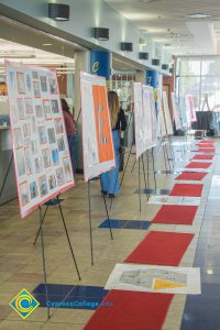 Row of small red rugs in front of display boards on easels in the Student Center.